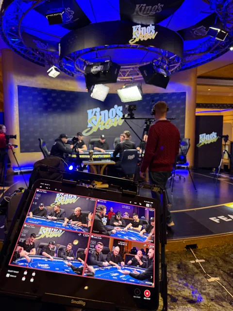 Štáb kolem pokerového stolu King’s Show a monitor se čtyřmi kamerovými záběry.