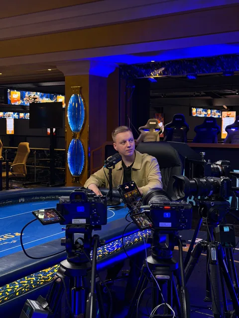 Several cameras on tripods around a poker table during shoot preparation.